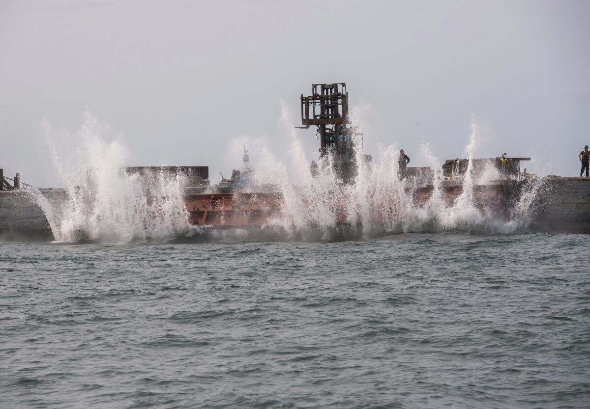 In this photo provided the Office of Governor Andrew M. Cuomo, an old rail car is dumped into the ocean a few miles off shore from Point Lookout, N.Y., Wednesday, Sept. 16, 2020. The debris will be used to create an artificial reef that will attract fish and other marine life. (Darren McGee/Office of Governor Andrew M. Cuomo via AP)