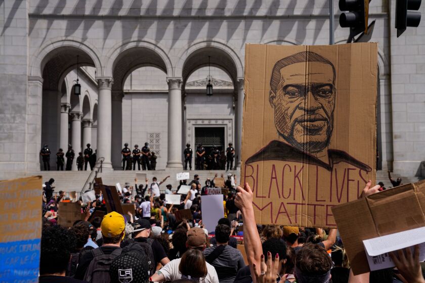 LOS ANGELES, CA - JUNE 02: Demonstrators raise a drawing of the late George Floyd while protesting in front of LA City Hall in downtown Los Angeles on Tuesday, June 2, 2020 in Los Angeles, CA. Protests have erupted across the country, with people outraged over the death of George Floyd, a black man killed after a white Minneapolis police officer pinned him to the ground with his knee. (Kent Nishimura / Los Angeles Times)