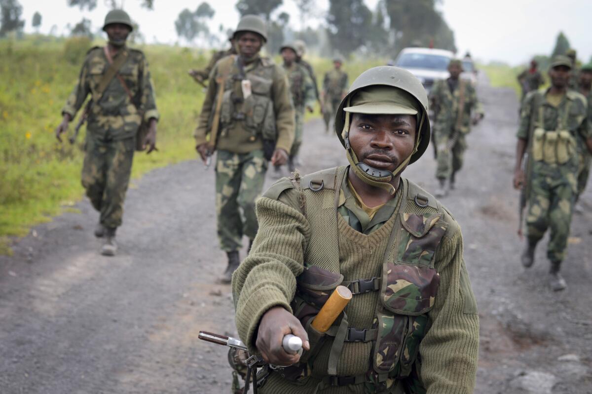 Congolese soldiers march through Kibumba on Monday after recapturing the town from M23 rebels over the weekend.
