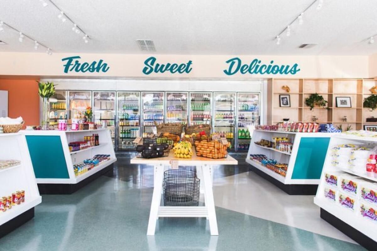 A bright turquoise and white market interior with the words Fresh Sweet Delicious in script above the room