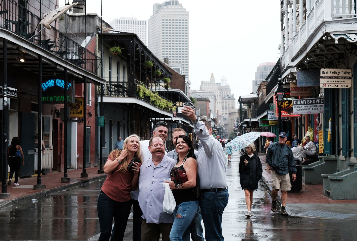 A group takes a photo on a slow Bourbon Street in New Orleans' French Quarter as Tropical Storm Barry approaches.