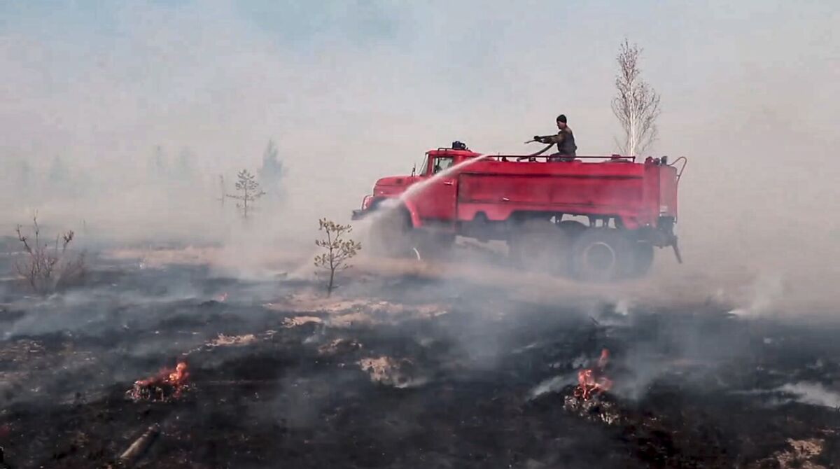 In this handout photo taken from video released by Russian Emergency Ministry Press Service on Tuesday, May 10, 2022, a firefighter works at the scene of a forest fire in Kurgan region, Russia. Russian President Vladimir Putin urged authorities on Tuesday to take stronger action to prevent wildfires and increase coordination between various official agencies in dealing with them. (Russian Emergency Ministry Press Service via AP)
