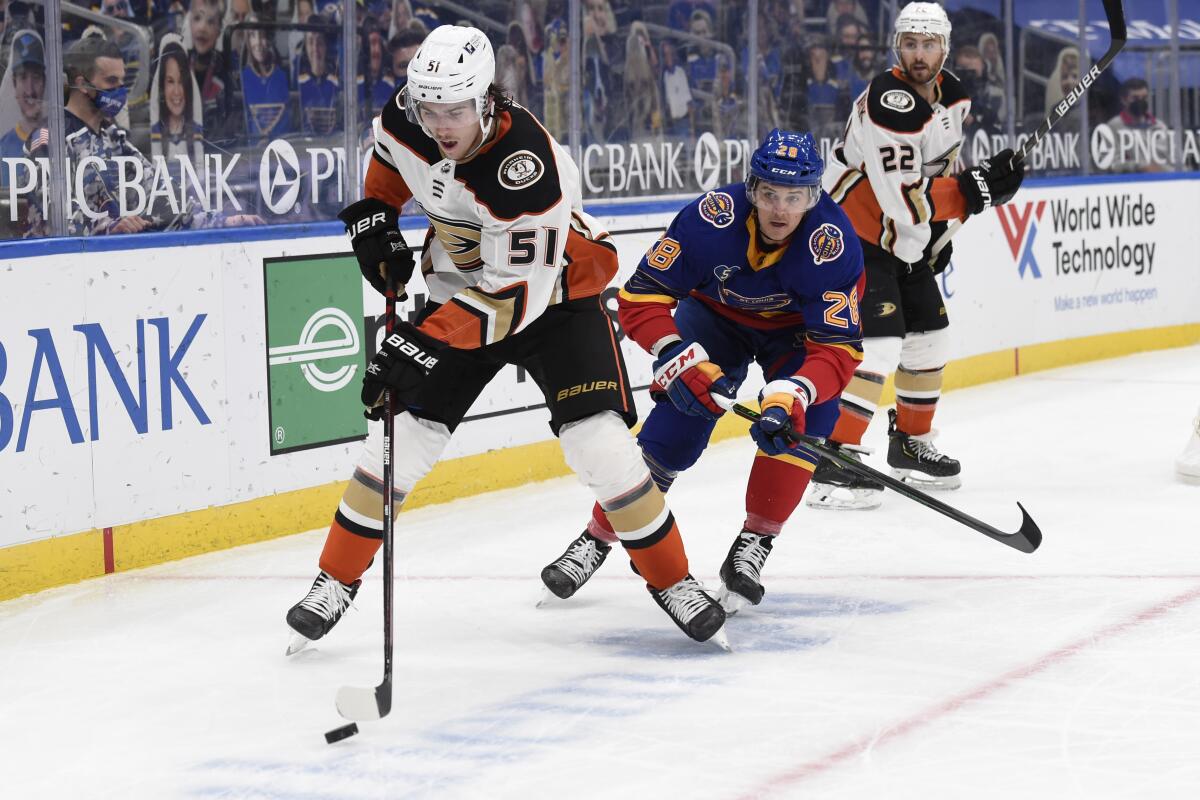 St. Louis Blues' Mackenzie MacEachern pressures Ducks' Haydn Fleury.