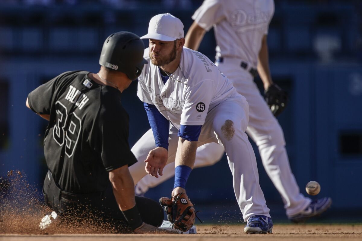 Yankees' Mike Tauchman steals second base in front of Dodgers second baseman Max Muncy.