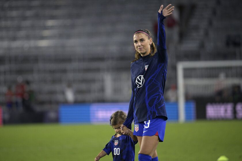 U.S. forward Alex Morgan, right, walks off the pitch with her daughter, Charlie Elena Carrasco after a SheBelieves Cup women's soccer match against Canada, Thursday, Feb. 16, 2023, in Orlando, Fla. (AP Photo/Phelan M. Ebenhack)