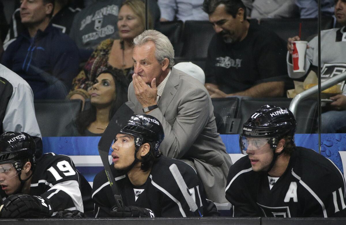 Kings Coach Darryl Sutter, center, watches from the bench during the second period of a loss to the Coyotes on Oct. 9.