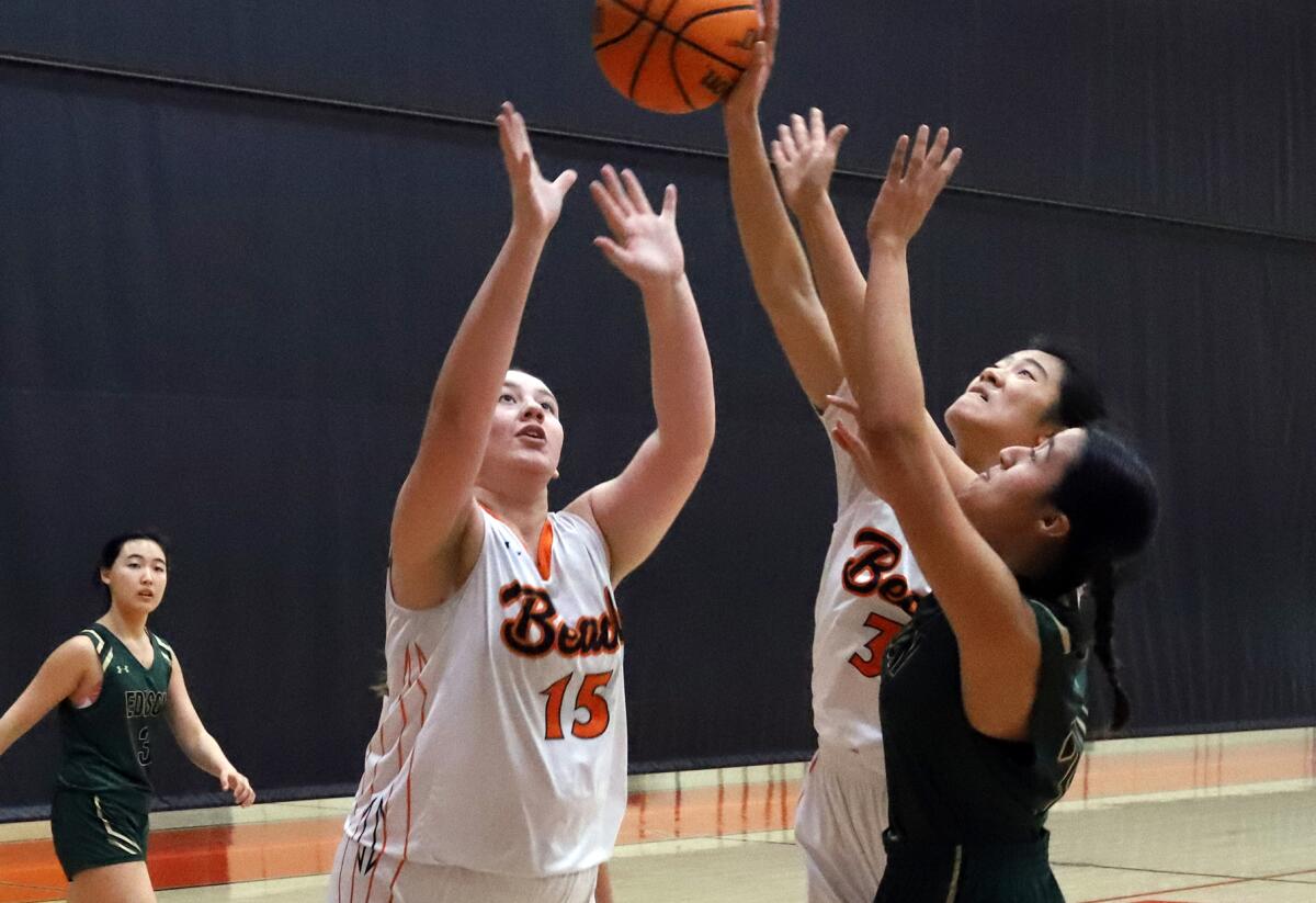 Huntington Beach's Melanie Rose (15), Chloe Nguyen (30) and Edison's Allison Sotelo (24) reach for a rebound on Saturday.