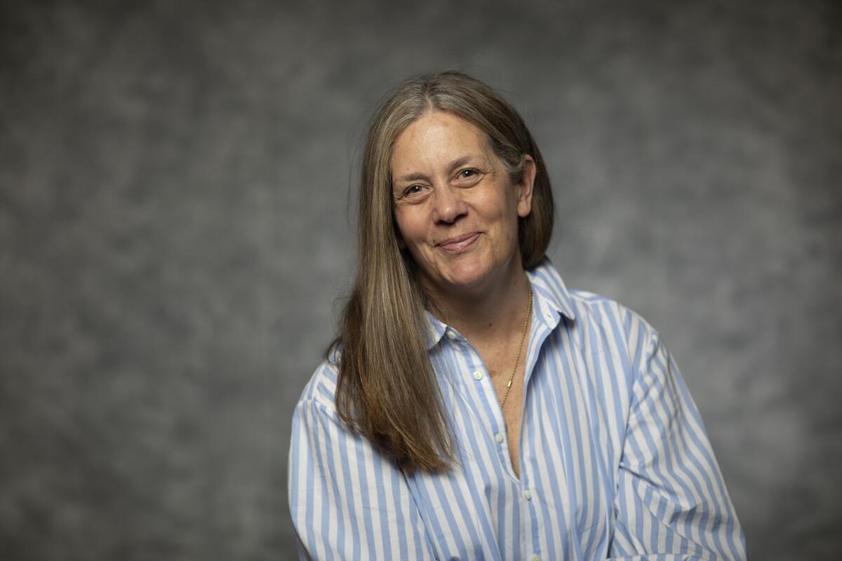 A woman in gray hair and a striped dress shirt.