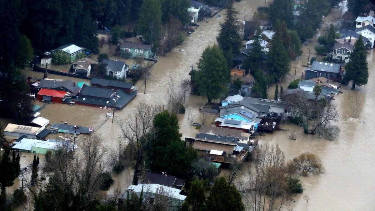 Homes and businesses sit under water in a flooded neighborhood in Guerneville.