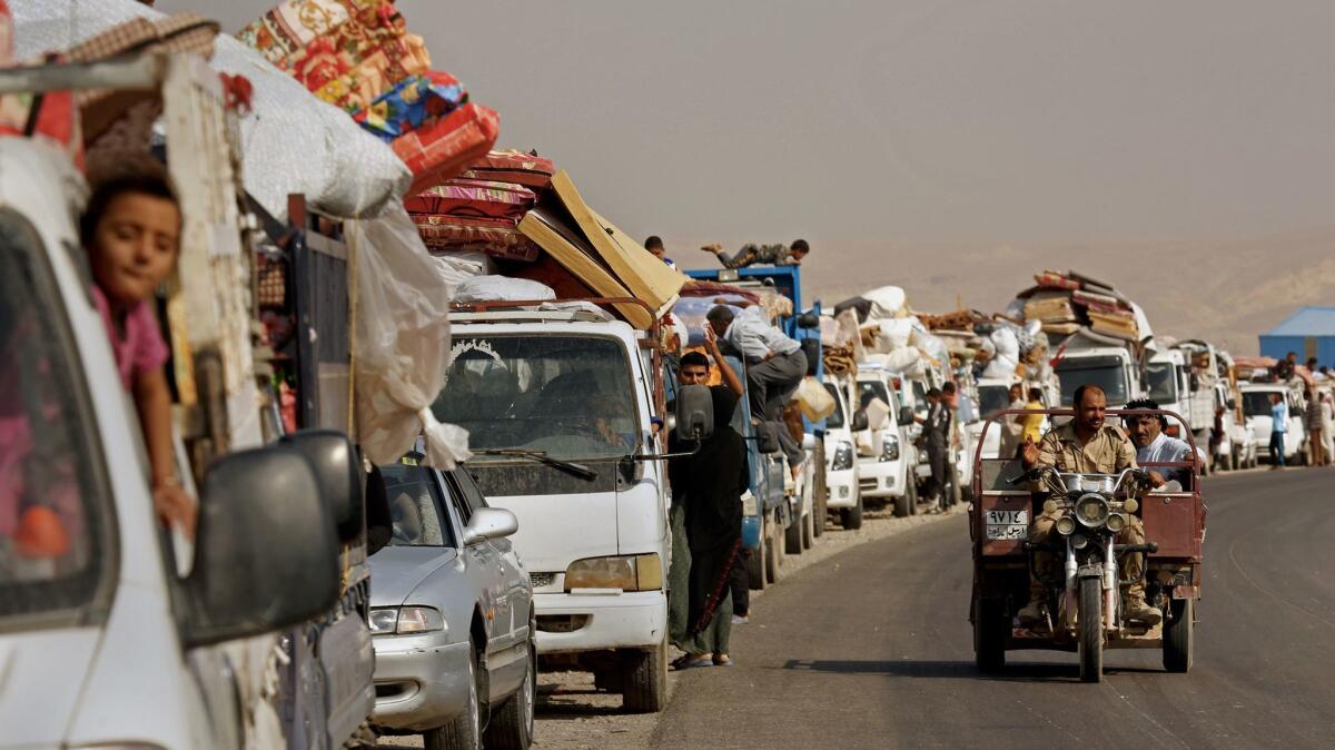 A convoy of Iraqi families attempt to return to their homes near Qayyarah, about three months after they were driven out by Islamic State fighters battling Iraqi forces.