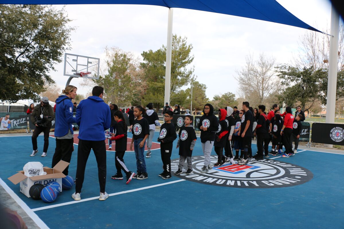 Children line up during a basketball event at Domenic Massari Park in Palmdale.