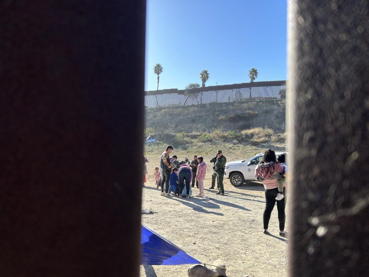 Migrant family units in formation at an open-air detention site between the border walls near San Ysidro, Calif.