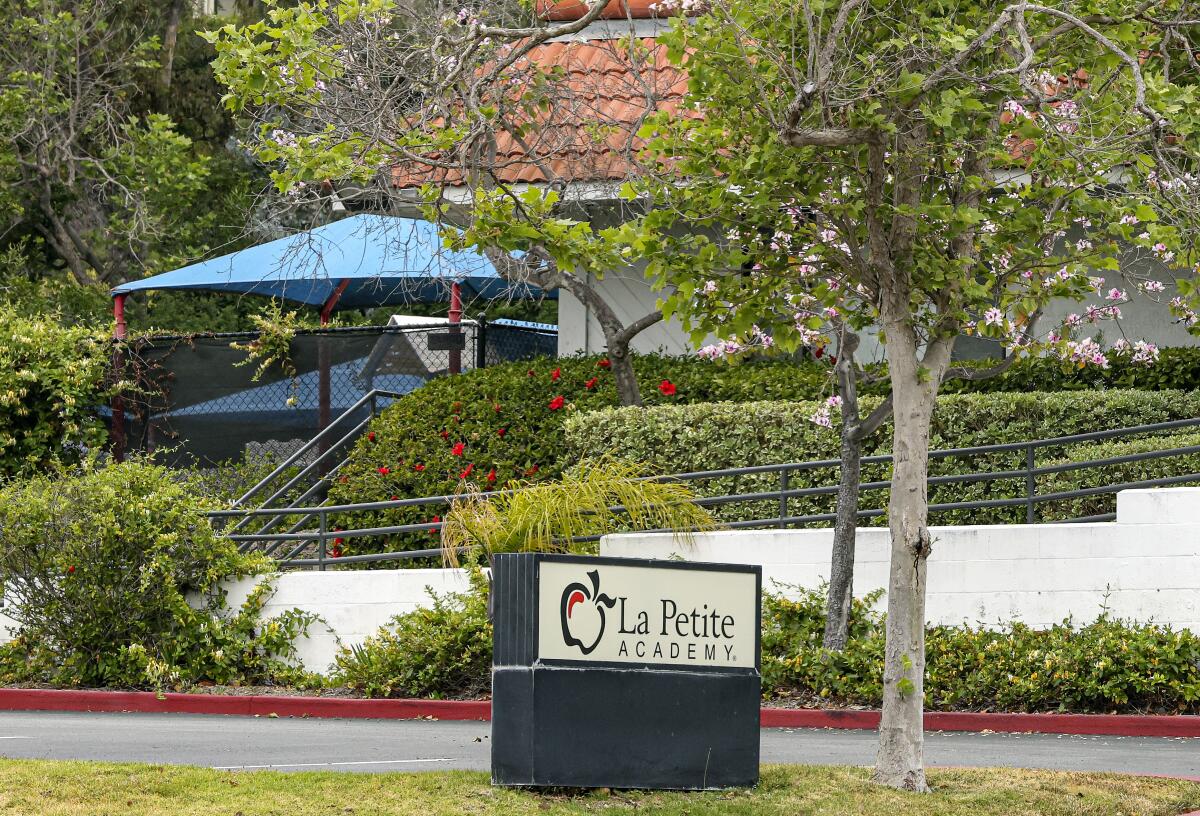 A sign in front of a building says "La Petite Academy."