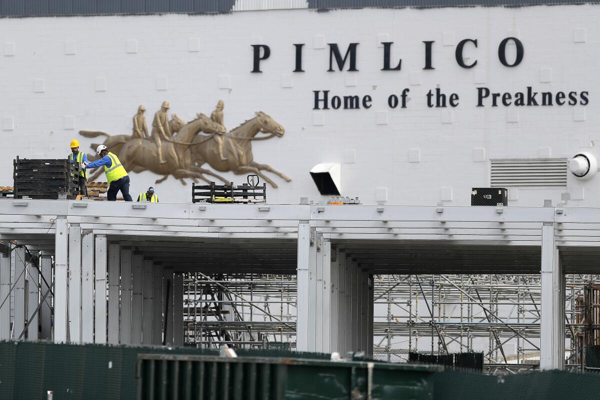A crew works on putting up a platform near the main entrance at Pimlico Race Course on May 15, 2020, in Baltimore.