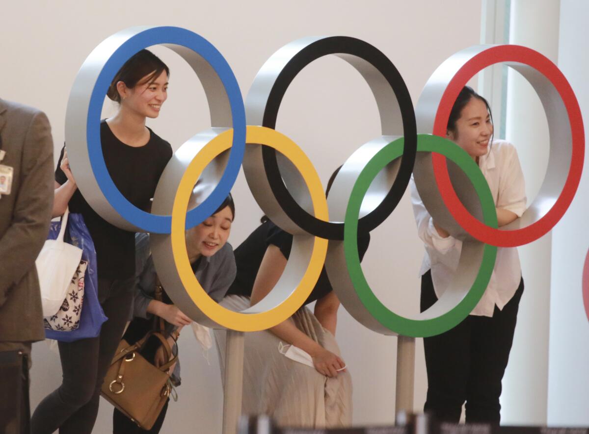 Gente posando para una foto con los anillos olímpicos en el aeropuerto internacional de Haneda, en Tokio.