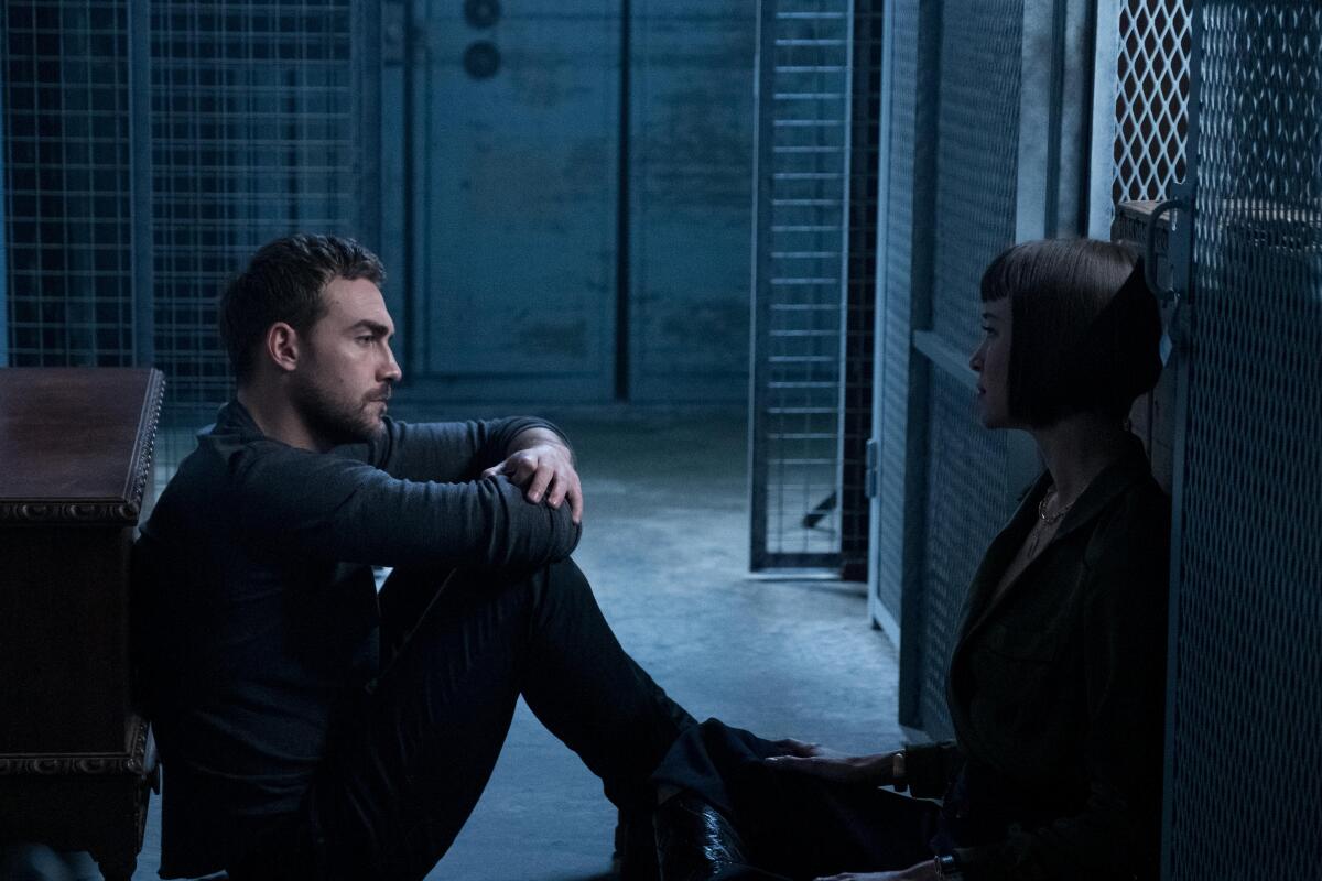 Tom Austen and Ana Helstrom face each other in a scene from the Marvel series "Helstrom"