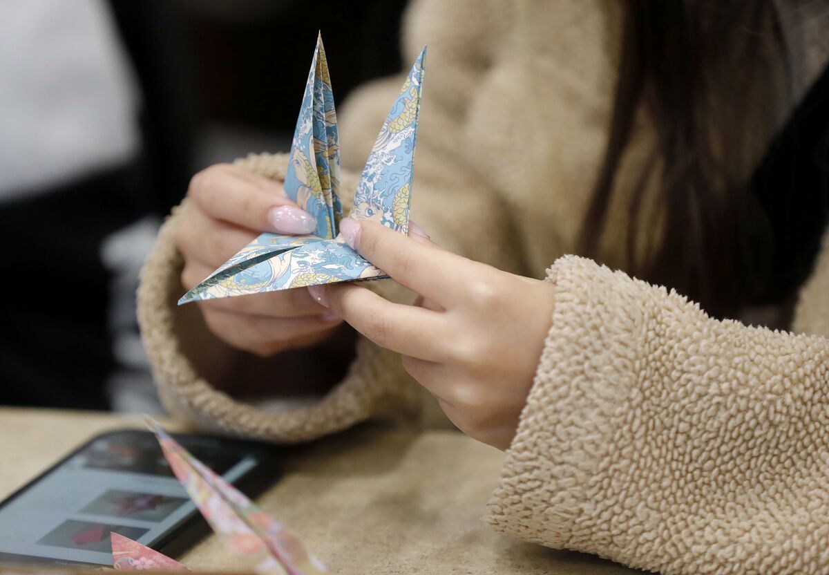 学生は伝統的な日本の折り紙や折り紙を練習します。