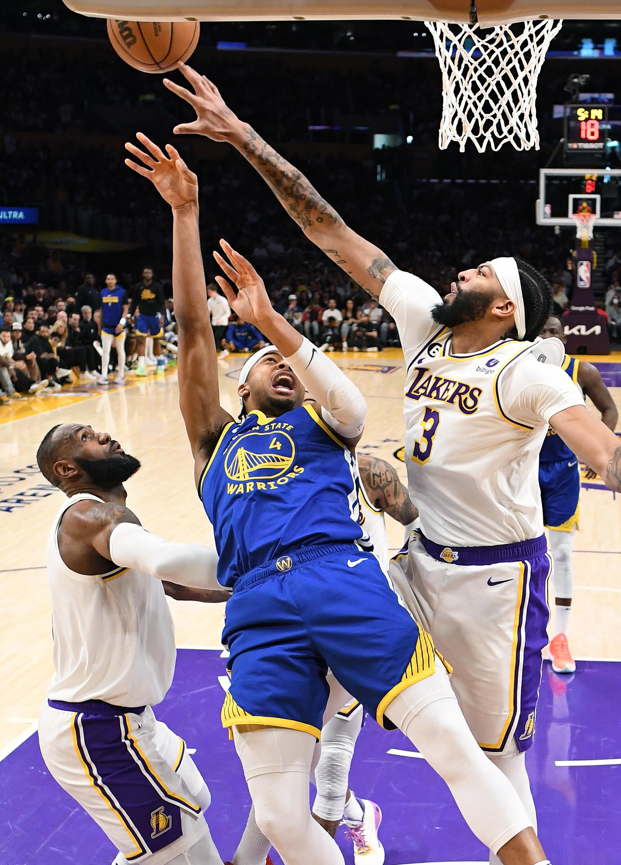 Lakers Anthony Davis blocks the shot of Warriors Moses Moody as LeBron James helps on defense in the first quarter.