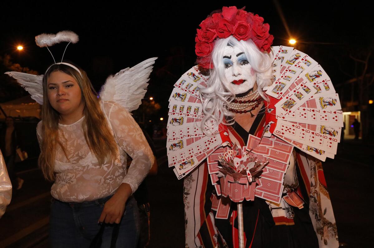 Lisa Lincoln, right, is the Queen of Hearts while joining the thousands of costumed revelers at the annual Halloween Carnaval.