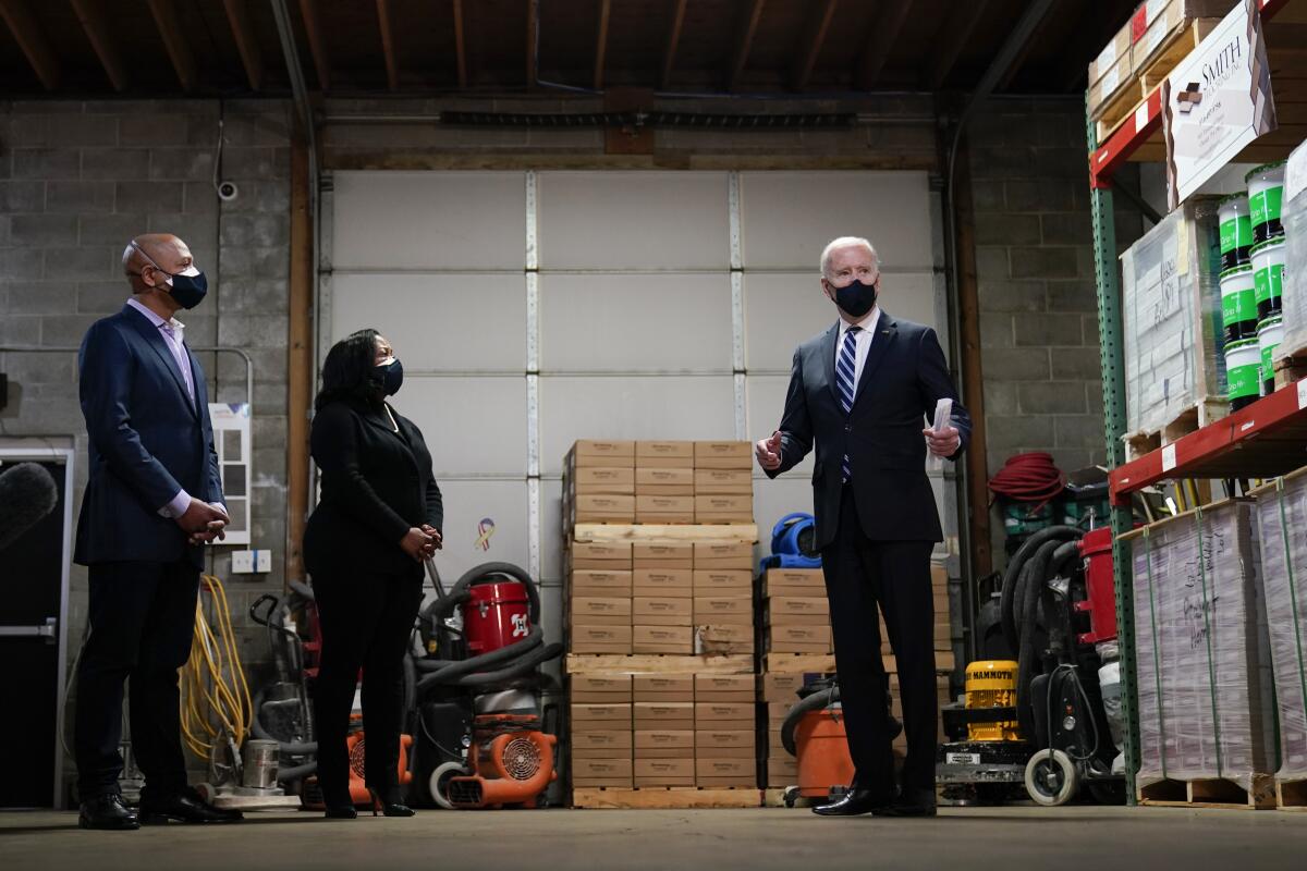 President Joe Biden speaks with owners Kristin Smith and James Smith as he visits Smith Flooring in Chester, Pa., Tuesday, March 16, 2021. (AP Photo/Carolyn Kaster)