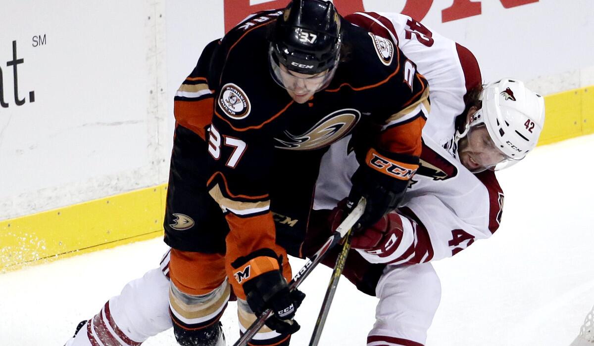Ducks defenseman Mat Clark (37) and Coyotes left wing Eric Selleck battle for the puck during the third period of a preseason game in Anaheim last month.