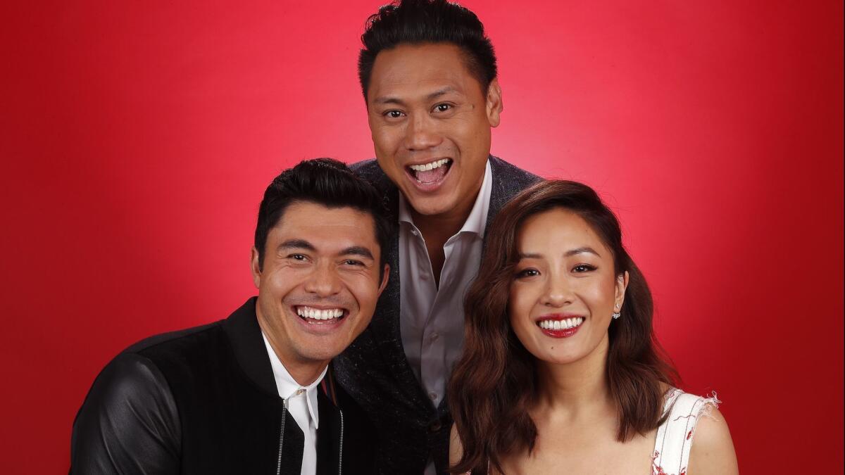 Jon M. Chu, center, director of the film "Crazy Rich Asians," poses with lead actors Henry Golding and Constance Wu, right, at the Beverly Wilshire hotel on Aug. 5.