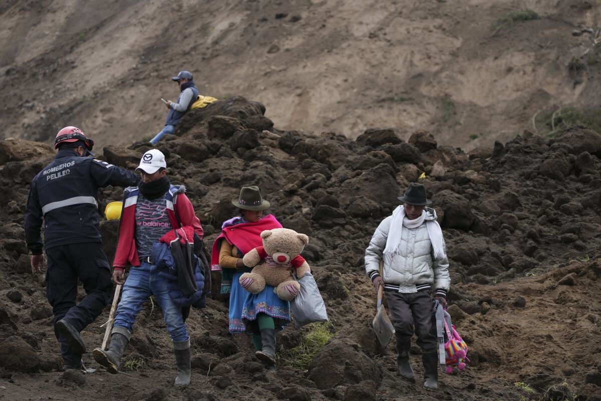 Residentes caminan en un área barrida por un deslizamiento de tierra en Alausí, Ecuador, 