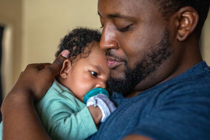Compton, CA - June 15: Danny Rollins, 32, holds his newborn Braylen Rollins in their home on Thursday, June 15, 2023, in Compton, CA. A new study finds that fathers can make a huge difference in determining whether their baby is successfully breastfed and put to sleep safely. Danny Rollins in Compton is the enthusiastic father of a five-week-old baby boy. Rollins doing everything he can to be supportive. (Francine Orr / Los Angeles Times)