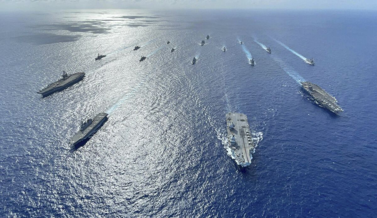In this photo released by the U.S. Indo-Pacific Command, the United Kingdom's carrier strike group led by HMS Queen Elizabeth (R 08), and Japan Maritime Self-Defense Forces led by (JMSDF) Hyuga-class helicopter destroyer JS Ise (DDH 182) joined with U.S. Navy carrier strike groups led by flagships USS Ronald Reagan (CVN 76) and USS Carl Vinson (CVN 70) sails to conduct multiple carrier strike group operations in the Philippine Sea, Oct. 3, 2021. A spate of recent Chinese military flights off Taiwan, which Beijing claims as its own, and naval maneuvers by the United States and its allies to reinforce maritime routes challenged by China are fueling increasing tensions in a region already on edge. (Gray Gibson/U.S. Navy via AP)