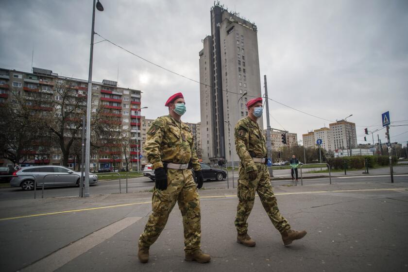 Two members of the military police patrol the streets in Budapest, Hungary, Monday, March 30, 2020. Due to the coronavirus pandemic, two days earlier the government implemented a lockdown. For two weeks, homes and residences may only be left for work or to purchase essential goods. Members of the police are tasked to ensure compliance with the rules by providing support and being empathetic with the residents. The new coronavirus causes mild or moderate symptoms for most people, but for some, especially older adults and people with existing health problems, it can cause more severe illness or death. (Zoltan Balogh/MTI via AP)