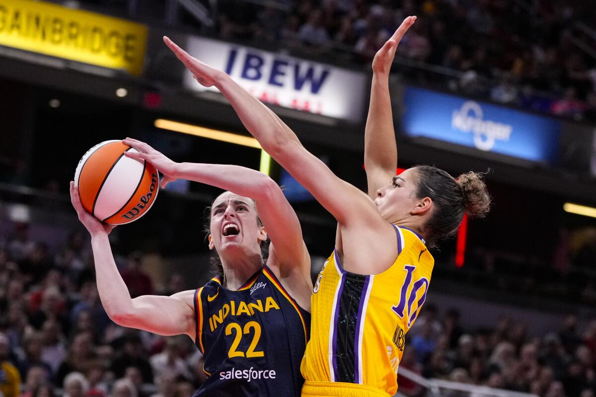 Sparks guard Kia Nurse, right, tries to block a layup by Fever guard Caitlin Clark during the first half Tuesday night.