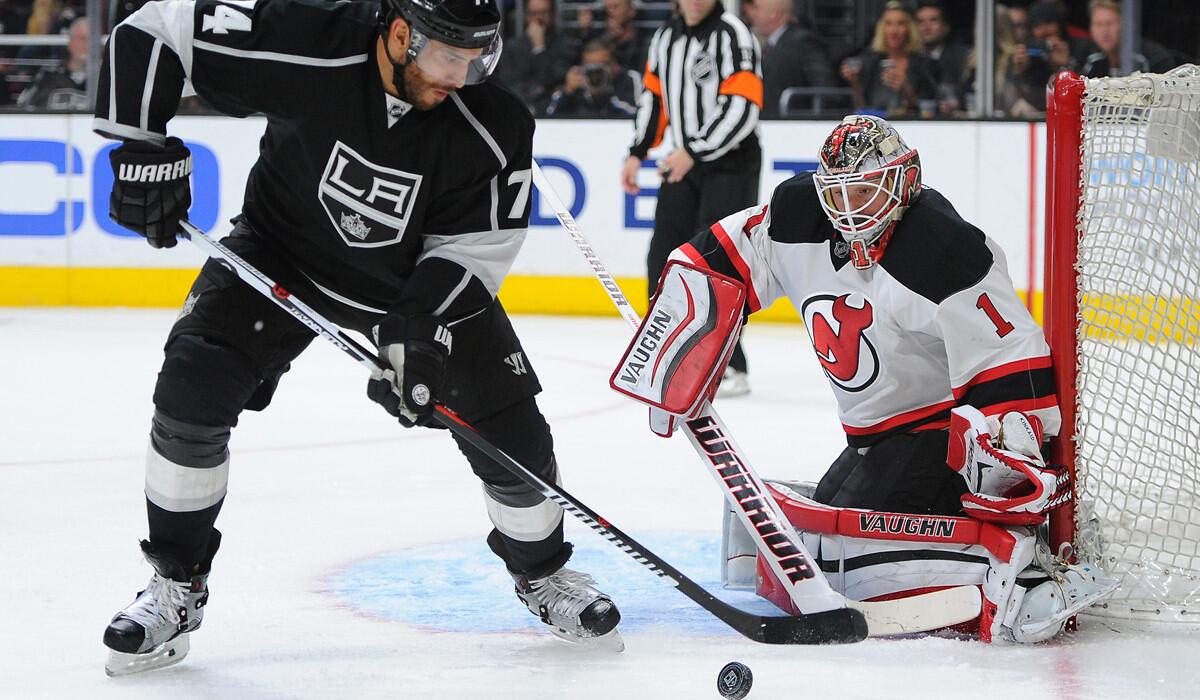 Kings forward Dwight King controls the puck in front of New Jersey Devils goalie Keith Kinkaid during the second period on Saturday.
