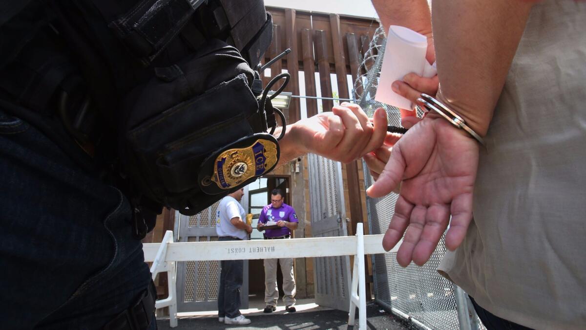 An ICE agent removes the handcuffs from a woman being deported to Mexico at the San Ysidro Port of Entry.