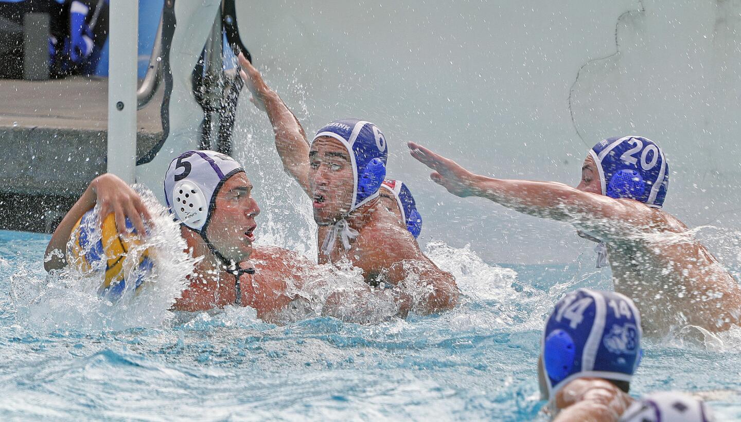 Burbank's Kourosh Dolatshani and Ford Roll rush to defend against a shot by Hoover's Nic Salandi in a Pacific League boys' water polo match at Burbank High School on Tuesday, October 2, 2018.