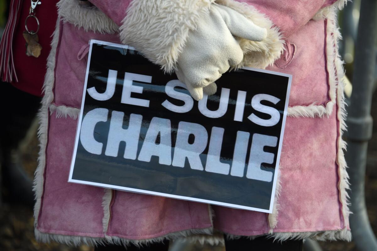 A woman holds a placard reading "Je suis Charlie" (I am Charlie) during the funeral of French cartoonist and Charlie Hebdo editor Stephane "Charb" Charbonnier in Pontoise, outside Paris, on January 16.