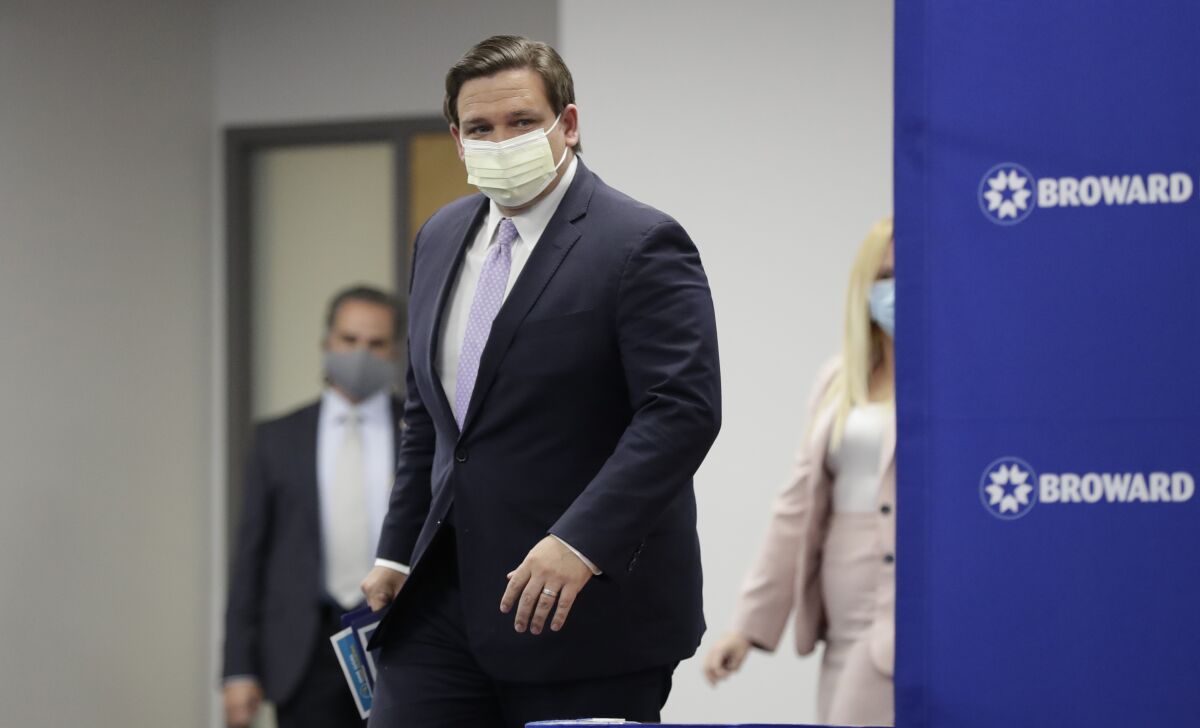 Florida Gov. Ron DeSantis arrives at a news conference, Monday, Aug. 3, 2020, at the Broward Health Corporate Office in Fort Lauderdale, Fla. On Friday, the governor's office released a video promoting "One Goal One Florida," a public service campaign that also urges Floridians to keep their distance and wear masks as a way to lower the risk of coronavirus infections. (AP Photo/Wilfredo Lee)