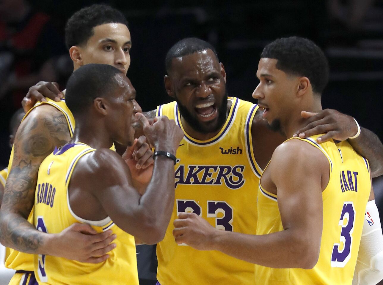 Lakers forward LeBron James huddles with his teammates during the season opener against the Trail Blazers.