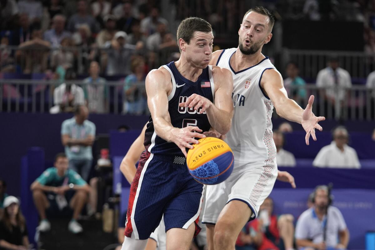 Jimmer Fredette, of the U.S., is under pressure from Serbia's Marko Brankovic during the men's 3x3 basketball match 