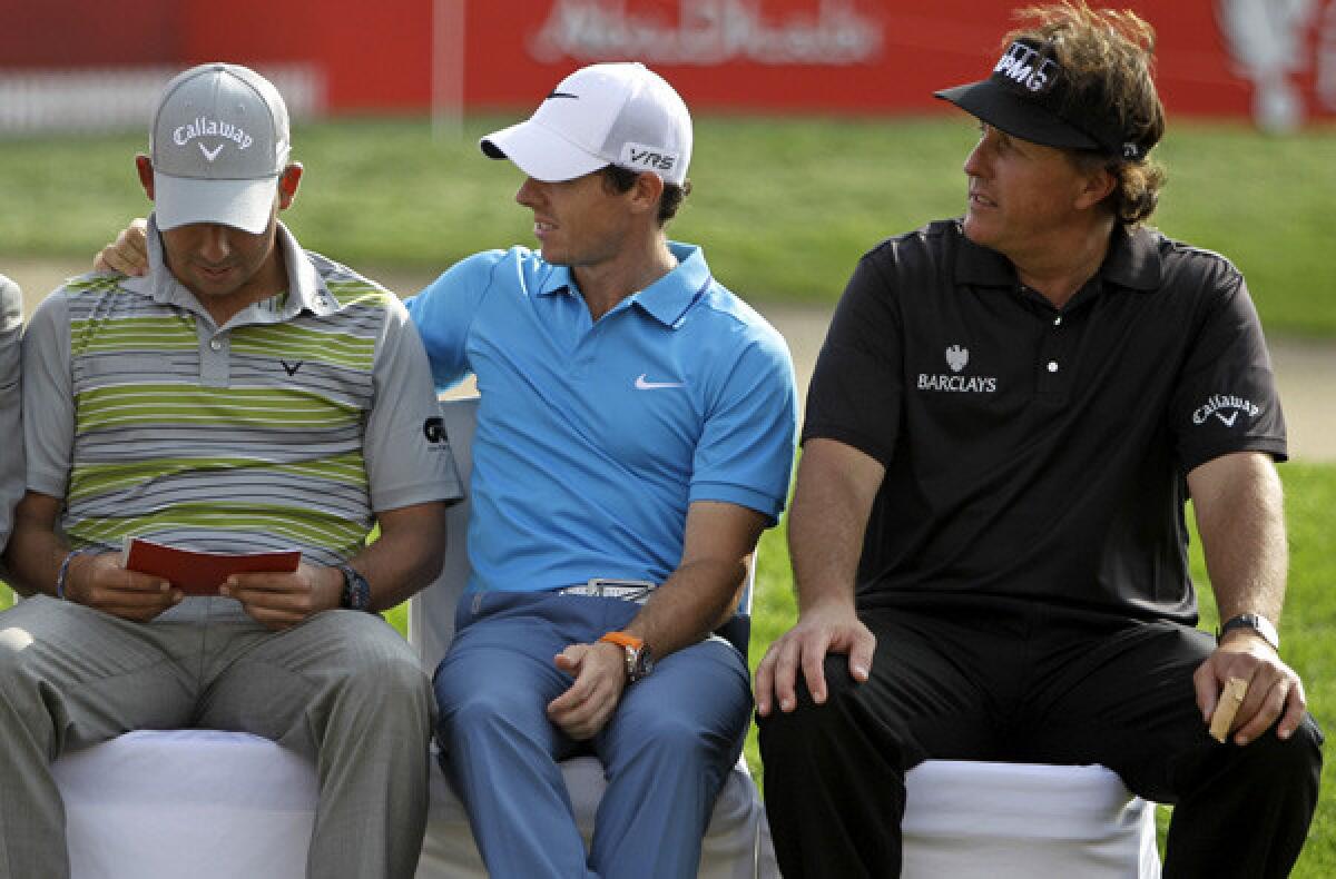 Rory McIlroy, center, talks to champion Pablo Larrazabal as they wait with Phil Mickelson for the awards ceremony at the Abu Dhabi HSBC Golf Championship.