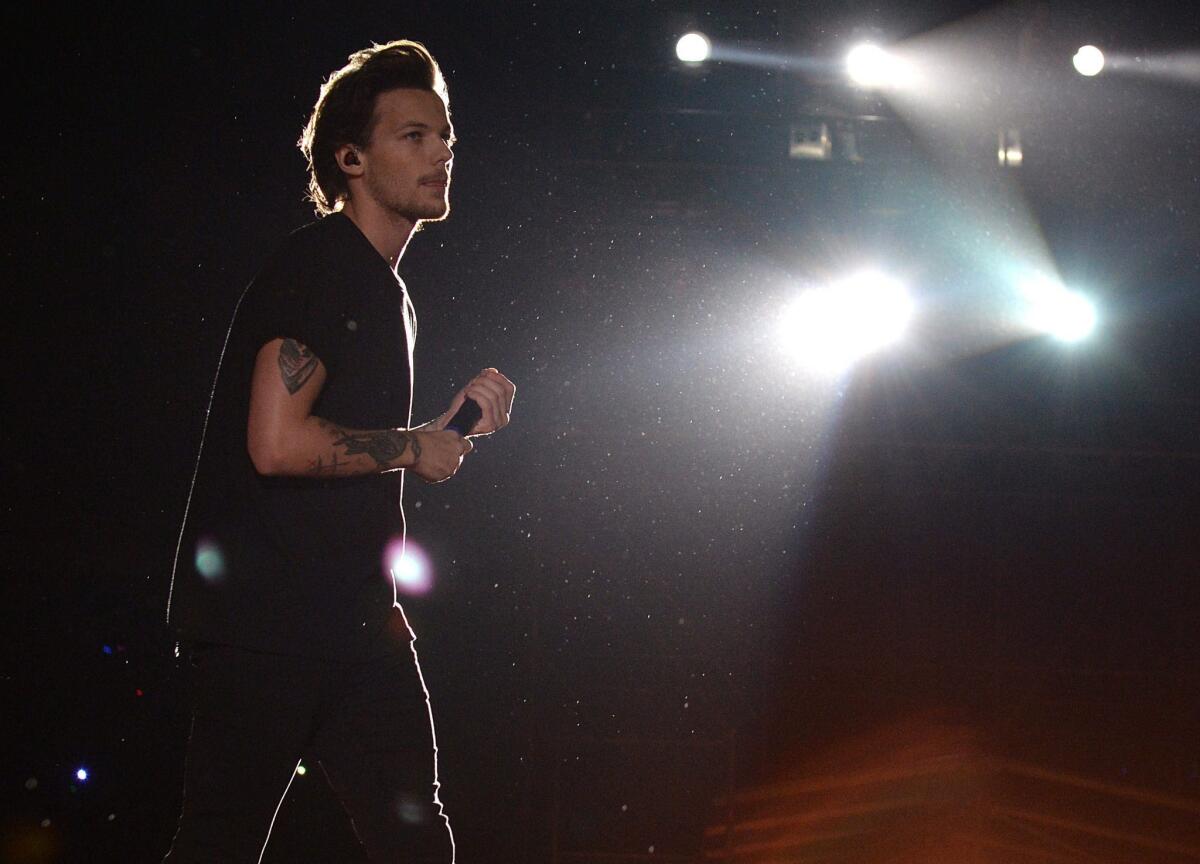 Louis Tomlinson of British pop group One Direction, shown during a May 3 performance in Argentina, appears in a video joking about marijuana use while smoking a rolled-up cigarette with bandmate Zayn Malik.