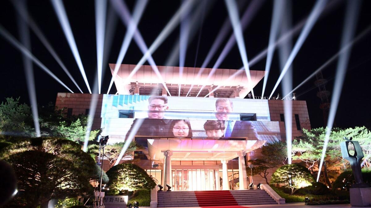 A picture of North Korea's leader Kim Jong Un and South Korea's President Moon Jae-in is beamed onto the Peace House during a closing ceremony at their historic summit at the truce village of Panmunjom.