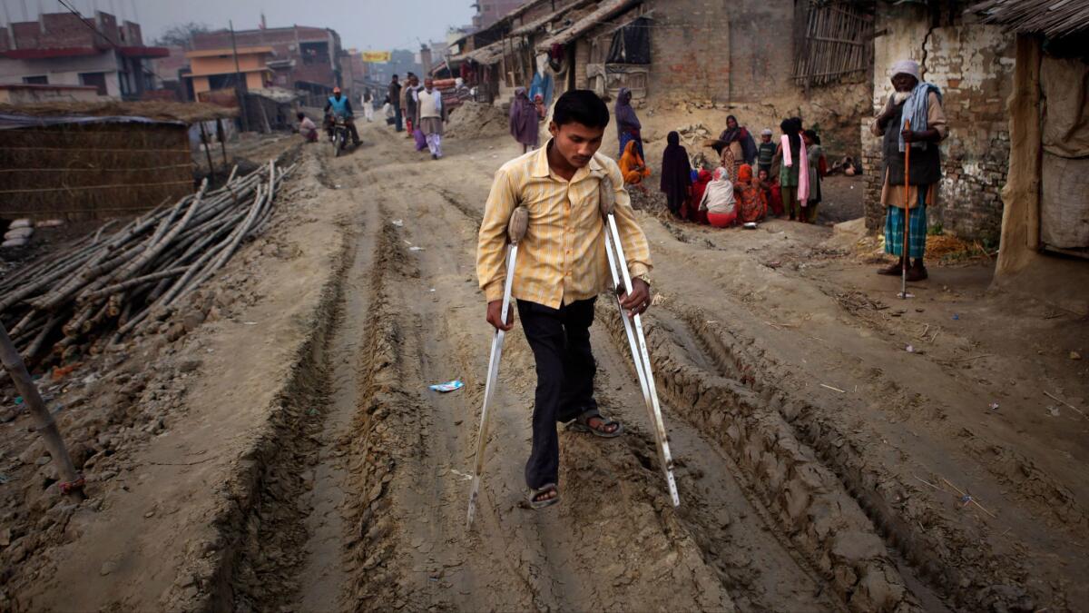 In this 2011 file photo, an unidentified man with polio walks on crutches in the village of Kosi, around113 miles from Patna, India.