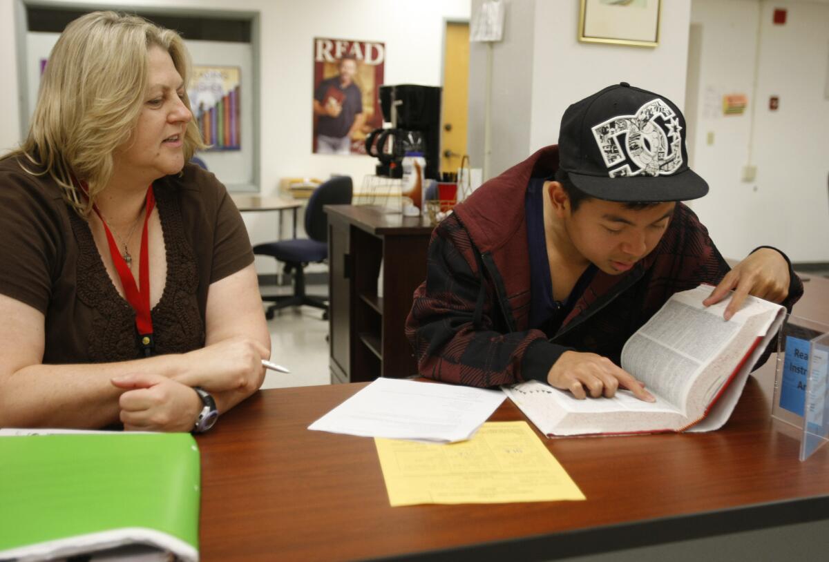 Reading tutor Carrie Jacoby, left, helps nursing student Albert Pamulaklakin, 21, with his reading class homework at the writing and reading success center at Long Beach City College.