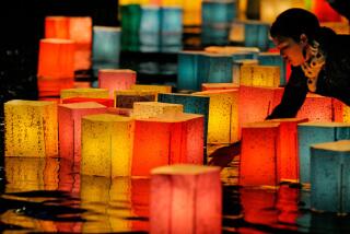 A woman floats a paper lantern on the Motoyasu River in Hiroshima to mark the 65th anniversary of the World War II atomic bombing of the city. Representatives from more than 70 nations, including for the first time the United States, joined tens of thousands at the emotional event.