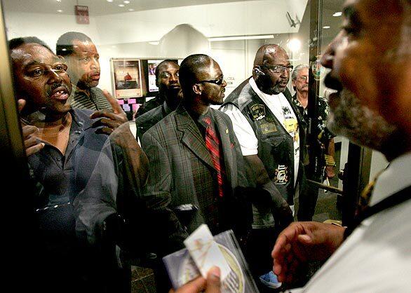 Inglewood Public Information Officer Ed Maddox, right, stops more community members from coming into the council chambers before the Inglewood City Council meeting Tuesday. Kevin Wicks was fatally shot by an Inglewood police officer, and the audience was at the meeting in protest.