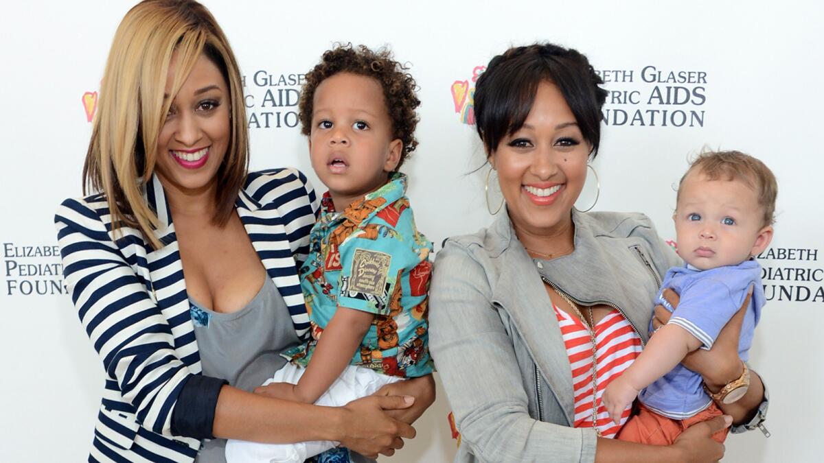 Tia Mowry-Hardrict, left, and Tamera Mowry-Housley with their kids at the 2013 "A Time for Heroes" carnival.