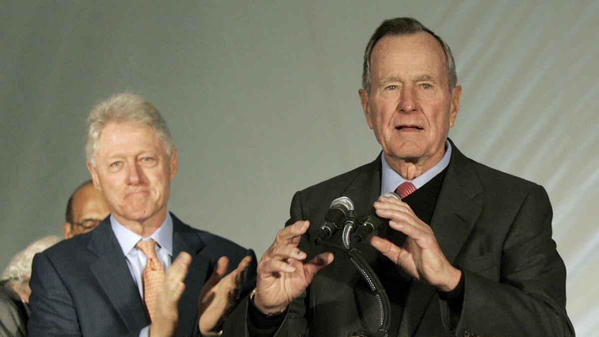 Former Presidents Bill Clinton, left, and George H.W. Bush appear together during a news conference where they spoke about money they raised for Hurricane Karina victims on Dec. 7, 2005.