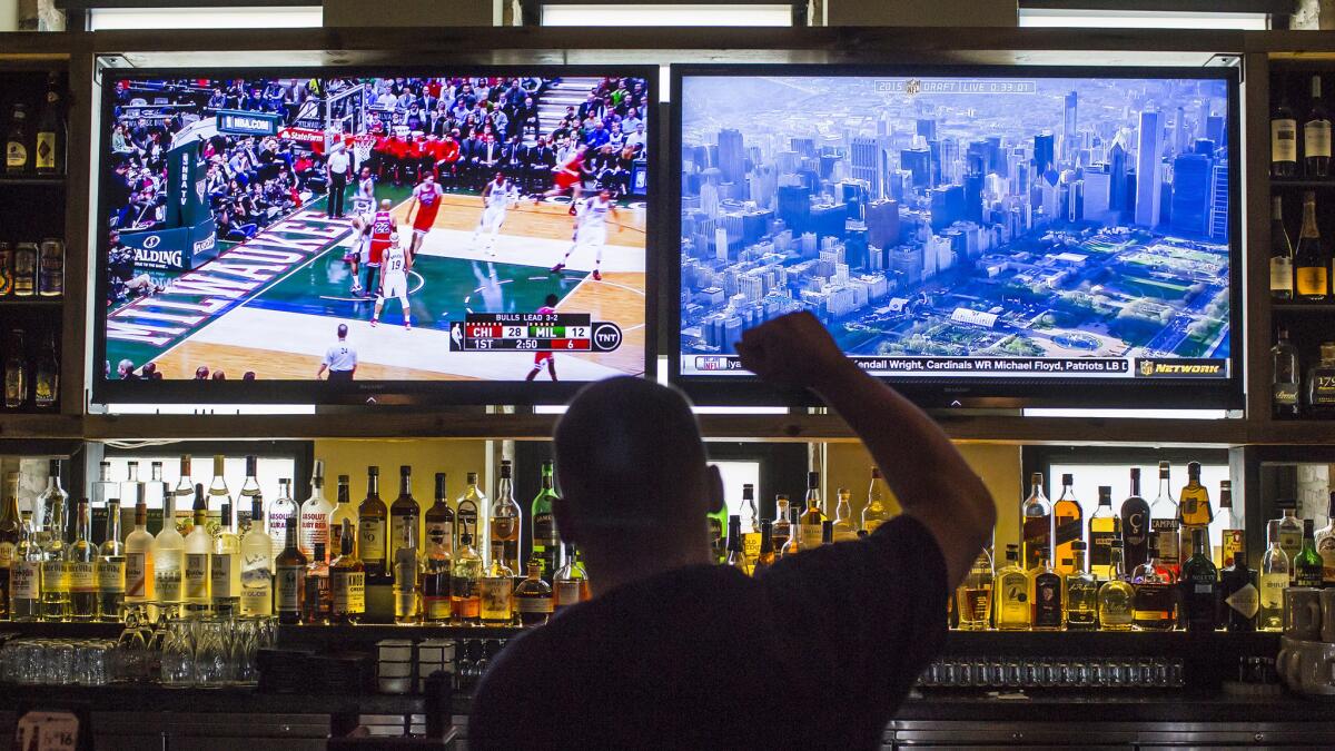 A patron of The Ogden in Chicago watches an April 30 playoff game between the Chicago Bulls and Milwaukee Bucks on television. The NBA's front office is in favor of legalizing nationwide betting on its games.