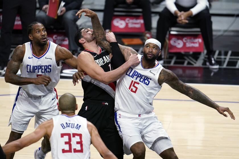 Los Angeles Clippers center DeMarcus Cousins (15) works for position under the basket next to Portland Trail Blazers center Enes Kanter, center, and Clippers' Kawhi Leonard, left, during the first half of an NBA basketball game Tuesday, April 6, 2021, in Los Angeles. (AP Photo/Marcio Jose Sanchez)
