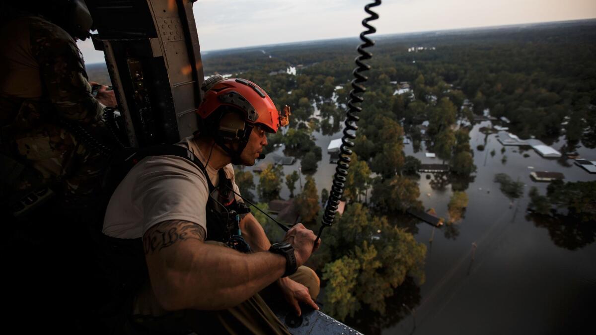 Master Sgt. Adam Vanhaaster with the California Air National Guard 129th Rescue Wing conducts a search and rescue mission in the flooded residential neighborhoods near Lumberton, Texas, on Aug. 31, 2017.